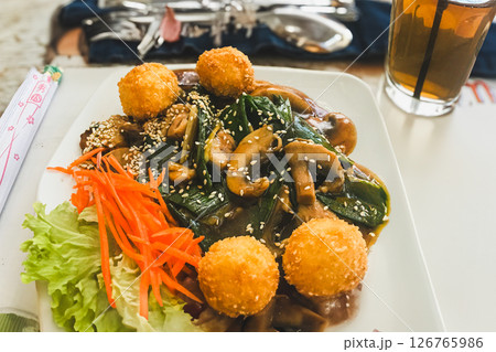 Fried fish balls in sweet and sour sauce with sesame seeds Fried fish balls in sweet and sour sauce with sesame seeds 126765986