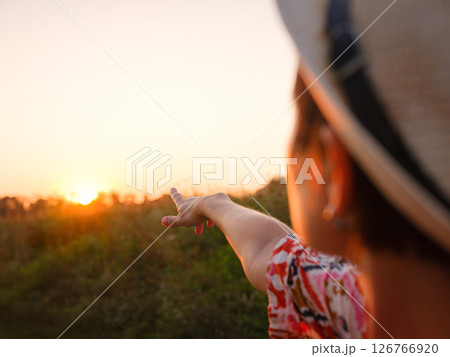 Warm sunset hues create peaceful, dreamy countryside atmosphere. 126766920