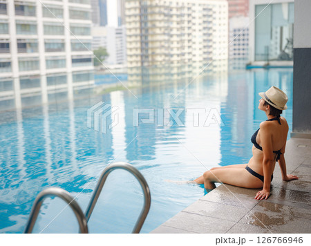 Young woman relaxing by the pool at a Kuala Lumpur hotel 126766946