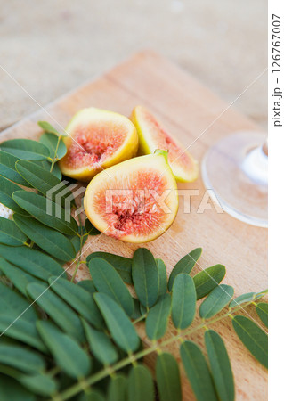 cut figs on a wooden board near the sea 126767007