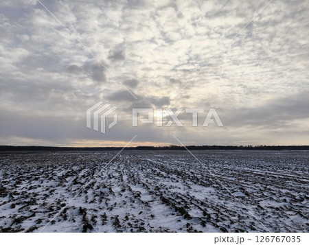 Snowy plowed field. plowed field covered with snow after a snowfall, an agricultural field in winter Snowy plowed field. plowed field covered with snow after a snowfall, an agricultural field in winter 126767035