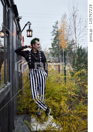 Exploring Dark Fashion with Striped Pants Set Against a Beautiful Autumnal Setting 126767219
