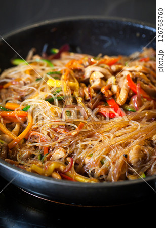 Asian glass noodle stir-fry with chicken and vegetables in a rustic ceramic  bowl 126768760
