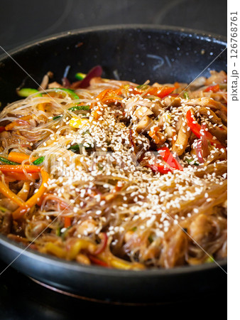 Asian glass noodle stir-fry with chicken and vegetables in a rustic ceramic  bowl 126768761