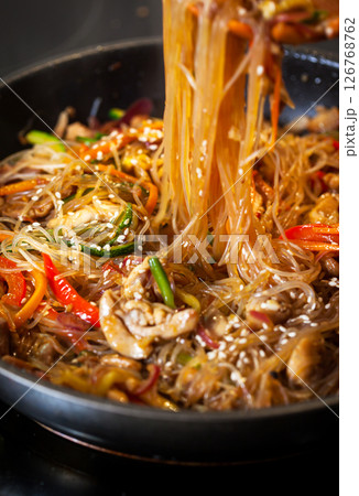 Asian glass noodle stir-fry with chicken and vegetables in a rustic ceramic bowl Asian glass noodle stir-fry with chicken and vegetables in a rustic ceramic bowl 126768762