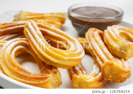 Traditional spanish dessert churros, fried dough pastry and chocolate macro, close up 126769254