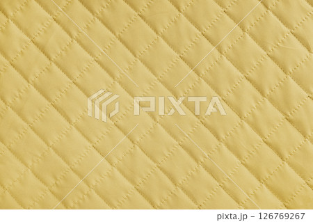 Checkered, diamond stitching pattern, yellow quilted fabric background. Blanket stitch texture 126769267