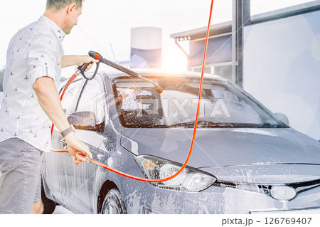 Man cleaning car. Spray hose foam soap. Car wash water shine exterior. 126769407