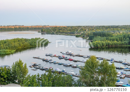 Boats docking at pier on river in summer evening Boats docking at pier on river in summer evening 126770150
