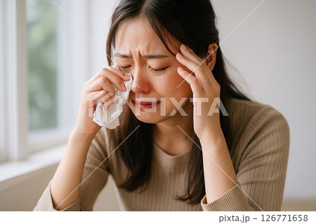 涙をこらえきれず泣く女性の横長ストックフォト素材 126771658
