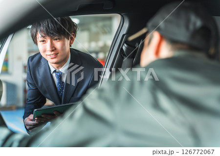 車内にいる作業着姿の作業員に指示をするスーツ姿の若いアジア人ビジネスマン 126772067
