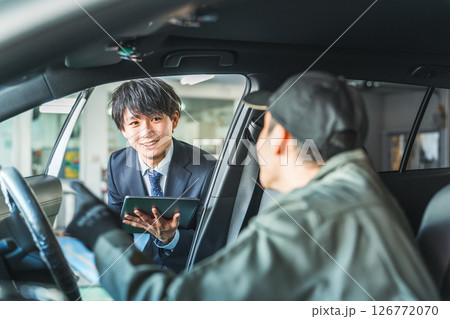 車内にいる作業着姿の作業員に指示をするスーツ姿の若いアジア人ビジネスマン 126772070