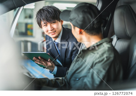 車内にいる作業着姿の作業員に指示をするスーツ姿の若いアジア人ビジネスマン 126772074