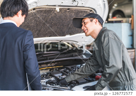 サービスフロントマンからご用命を聞く自動車整備士の男性（メカニック・サービスエンジニア・整備士） 126772577