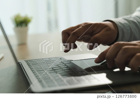 Call center person using laptop computer bright room with natural light and potted plant background. person is typing or navigating keyboard Call center person using laptop computer bright room with natural light and potted plant background. person is typing or navigating keyboard 126773800
