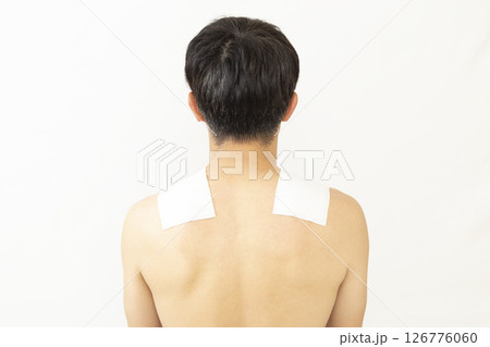 湿布を貼った男性の後ろ姿 白バック 湿布を貼った男性の後ろ姿 白バック 126776060