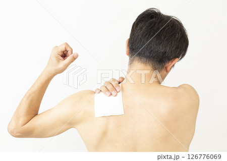湿布を貼った男性の後ろ姿　白バック 126776069