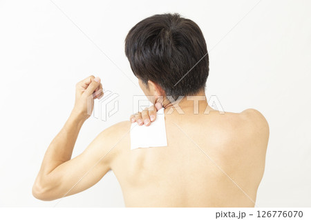 湿布を貼った男性の後ろ姿　白バック 126776070