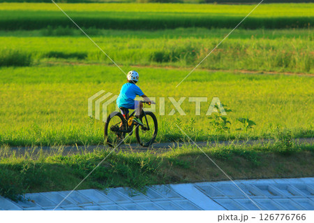 夏の夕方を自転車に乗った少年がゆく 126776766