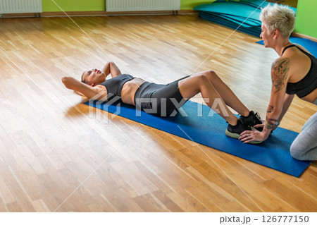 Athletic Girl Doing Sit-ups with Help Athletic Girl Doing Sit-ups with Help 126777150