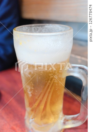 冷えたジョッキに注がれた泡立つ生ビール 冷えたジョッキに注がれた泡立つ生ビール 126778474