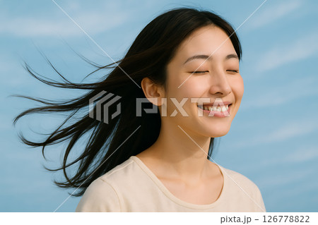 風を感じて目を閉じ笑顔を見せる若い日本人女性の横顔 風を感じて目を閉じ笑顔を見せる若い日本人女性の横顔 126778822