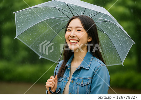 雨の日に傘を差して笑う若い日本人女性の後ろ姿 雨の日に傘を差して笑う若い日本人女性の後ろ姿 126778827