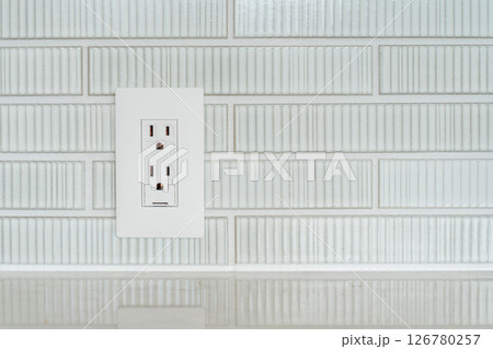 タイルの壁についたアース付きコンセント 126780257