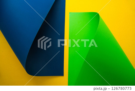 Vibrant blue and green paper shapes contrasted against a yellow background in a minimalist design Vibrant blue and green paper shapes contrasted against a yellow background in a minimalist design 126780773