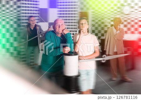 Kids and grandparents thinking about conundrum solution in escape room Kids and grandparents thinking about conundrum solution in escape room 126781116