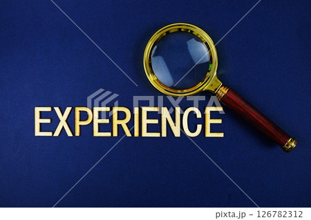 Experience alphabet letters with magnifying glass on navy blue background 126782312