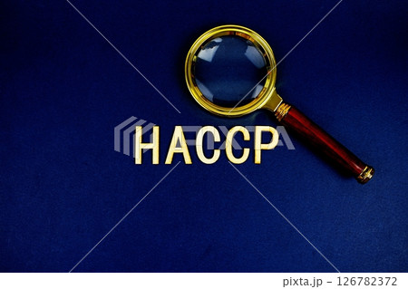 HACCP alphabet letters with magnifying glass on navy blue background 126782372