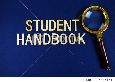 Student Handbook alphabet letters with magnifying glass on navy blue background Student Handbook alphabet letters with magnifying glass on navy blue background 126783174