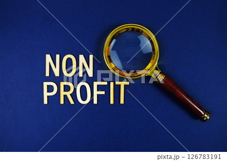 Non Profit alphabet letters with magnifying glass on navy blue background Non Profit alphabet letters with magnifying glass on navy blue background 126783191