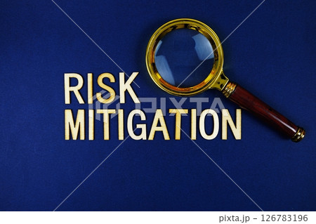 Risk Mitigation alphabet letters with magnifying glass on navy blue background 126783196