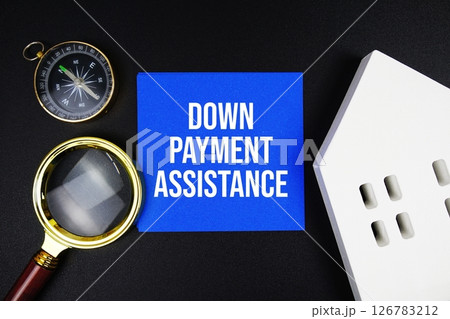 Down Payment Assistance text message with white house model and magnifying glass on black background 126783212
