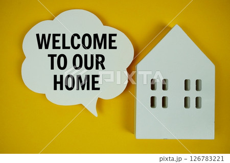 Welcome To Our Home text message on speech bubble with house model on yellow background 126783221