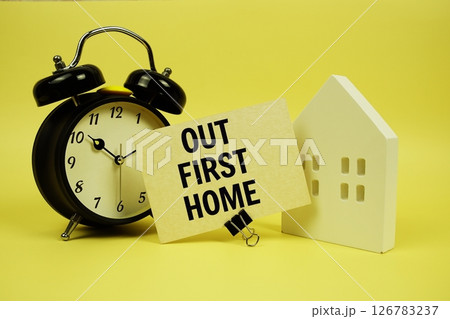 Our First Home text with house model and alarm clock on yellow background 126783237