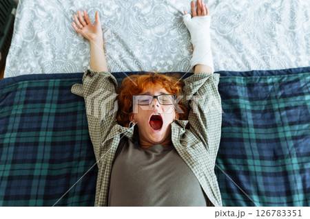 Teen girl with broken arm, wearing glasses, red hair, in bedroom 126783351