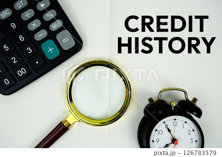 Credit History text message written on note page with calculator, alarm clock and magnifying glass 126783579