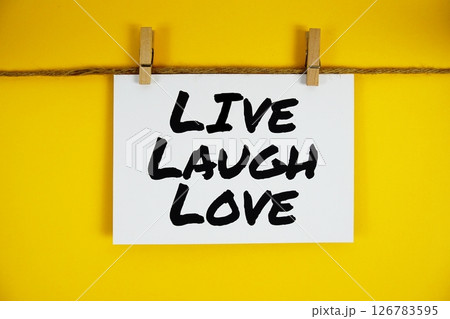 Live Laugh Love text on paper card on yellow background 126783595
