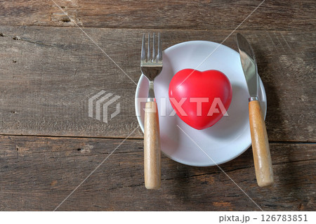 Red heart on dish and table knife and fork . Red heart on dish and table knife and fork . 126783851