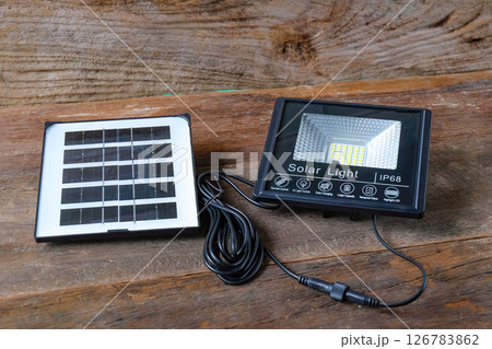 Solar lighting and solar panel on wood table ,Ecological electrical energy . Solar lighting and solar panel on wood table ,Ecological electrical energy . 126783862