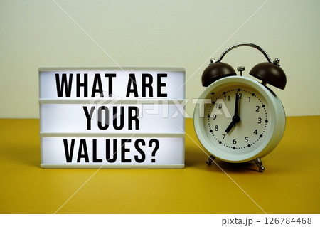 What Are Your Values? text on LED lightbox with alarm clock on yellow background 126784468