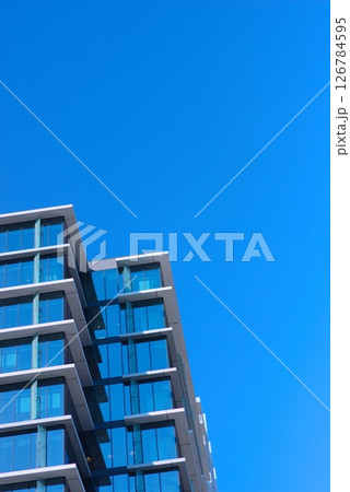 都市にそびえるガラス張りの高層ビルと青空の構図 126784595