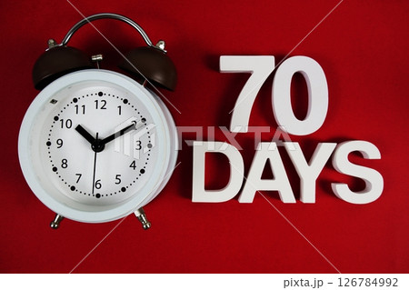 70 Days alphabet letters with alarm clock on red background 126784992