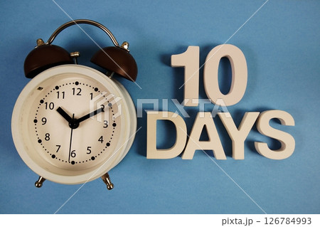 10 Days alphabet letters with alarm clock on blue background 126784993