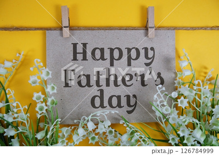 Happy Father's Day text on paper card with flower blooming decoration on yellow background 126784999