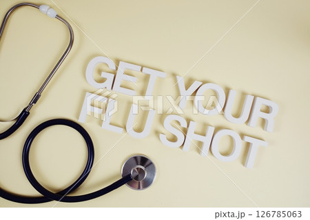 Get Your Flu Shot alphabet letters with stethoscope top view on yellow background Get Your Flu Shot alphabet letters with stethoscope top view on yellow background 126785063