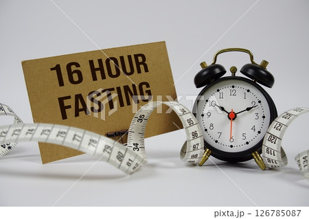 16 Hour Fasting text with alarm clock and measure tape on white background 126785087